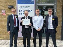 Four men in suits at the opening of a new medical facility